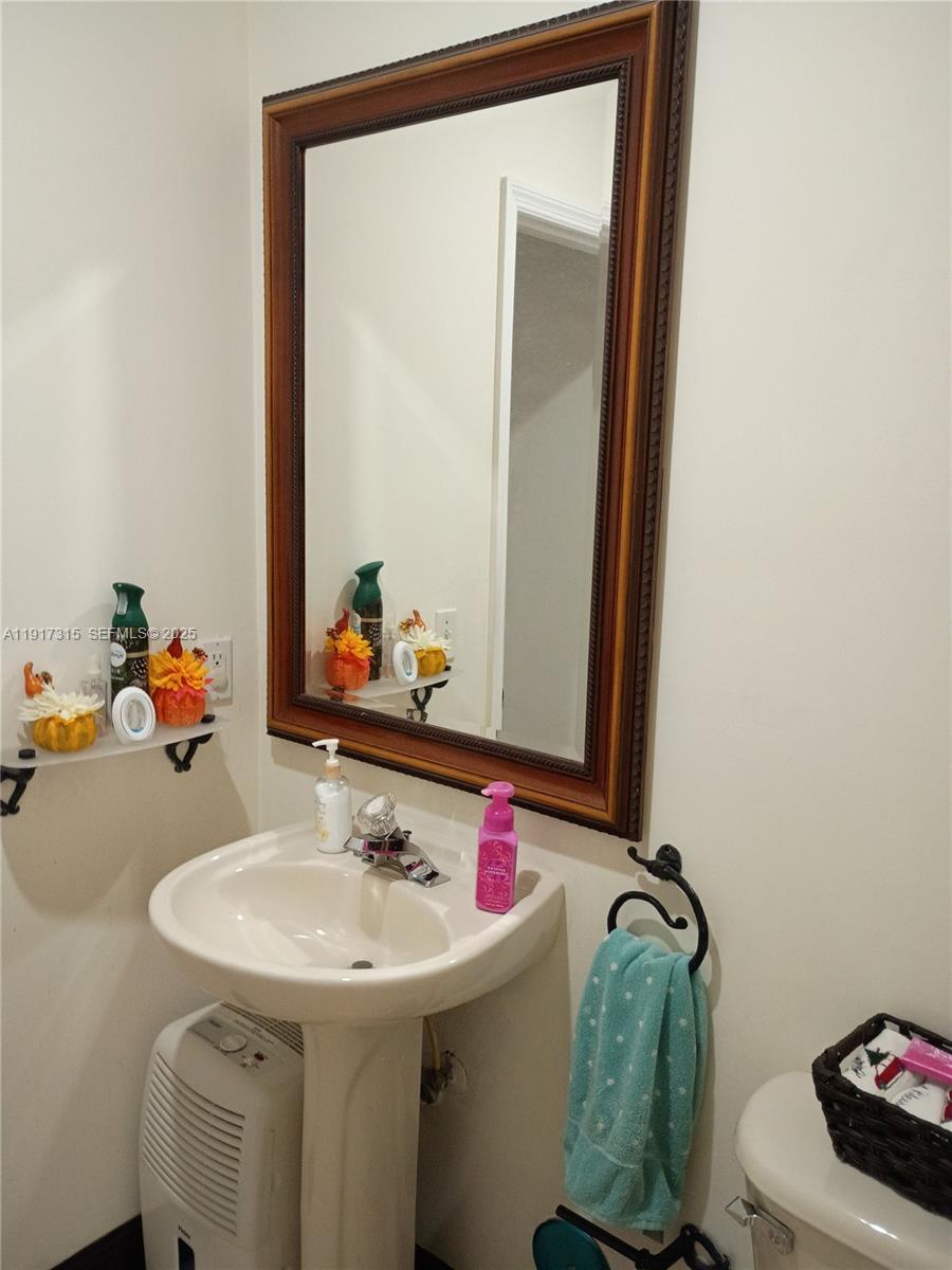 13274 Southwest 142nd Terrace, Unit 13274 Miami, FL 33186 - Photo 14 of 32 a bathroom with a sink and a mirror
