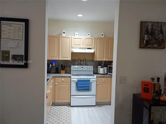 a kitchen with stainless steel appliances granite countertop a stove a refrigerator and a microwave