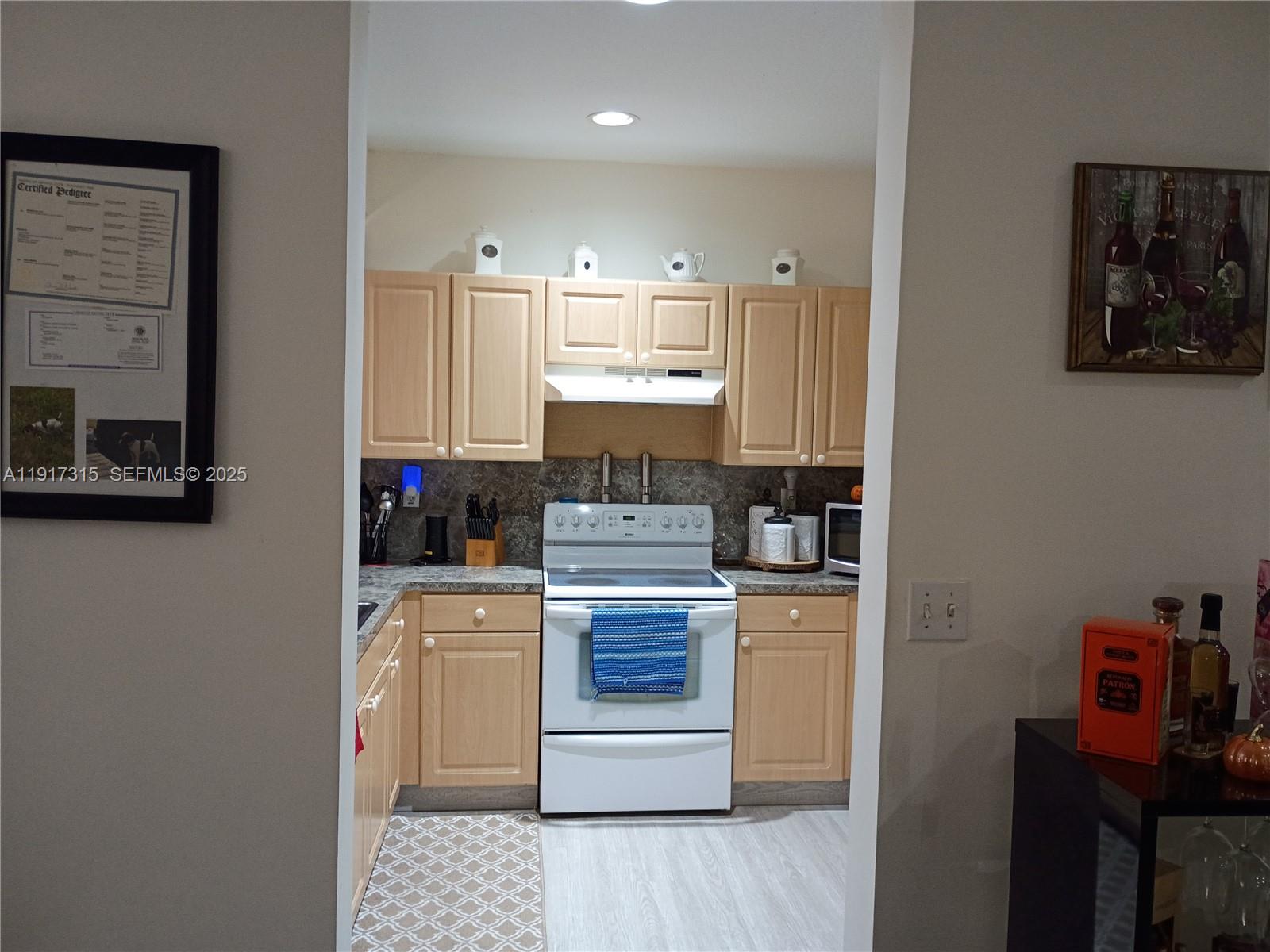 13274 Southwest 142nd Terrace, Unit 13274 Miami, FL 33186 - Photo 16 of 32 a kitchen with stainless steel appliances granite countertop a stove a refrigerator and a microwave