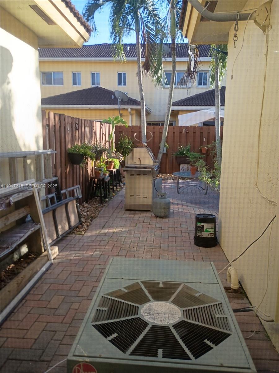 13274 Southwest 142nd Terrace, Unit 13274 Miami, FL 33186 - Photo 30 of 32 a view of a patio with couches chairs and potted plants
