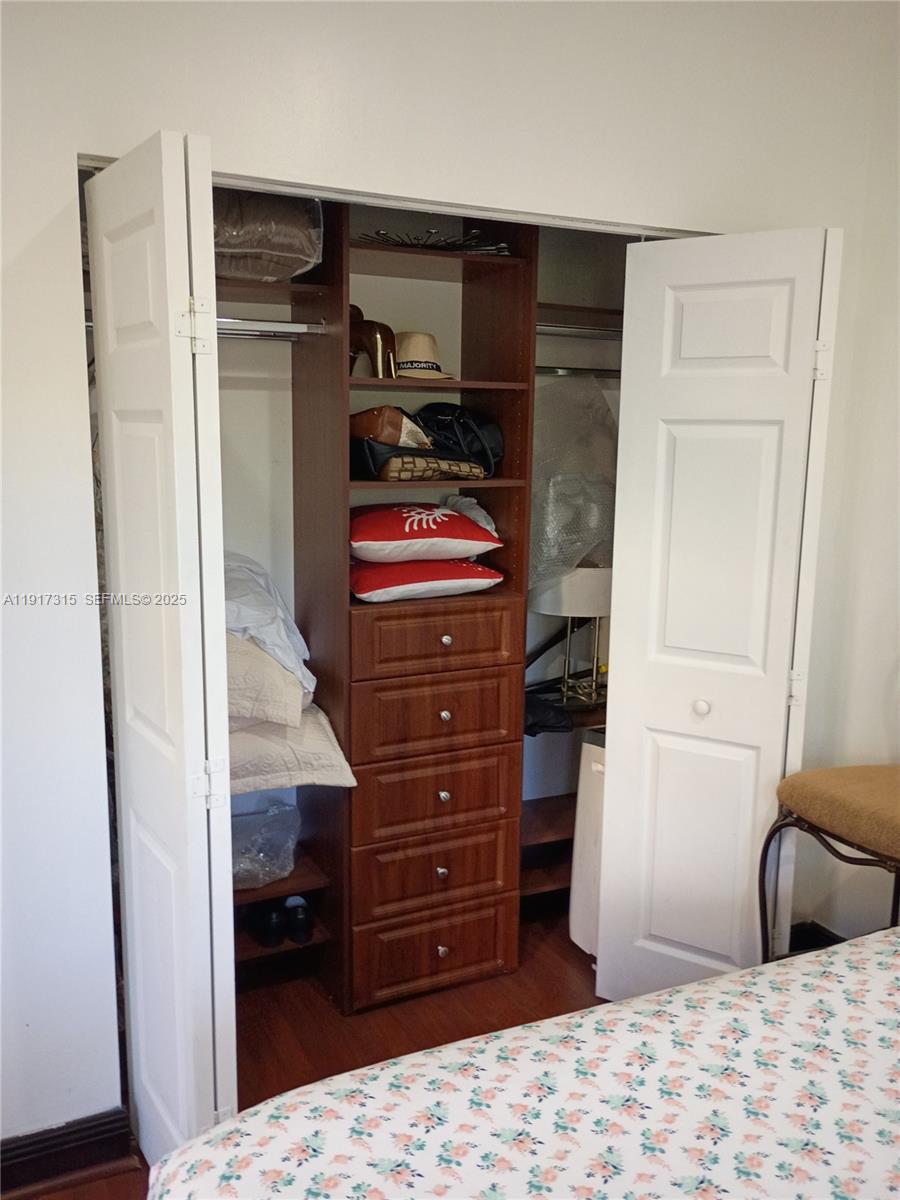 13274 Southwest 142nd Terrace, Unit 13274 Miami, FL 33186 - Photo 31 of 32 a bedroom with a bed and a dresser