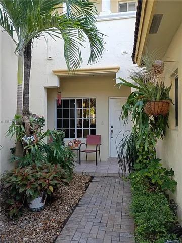 a view of a house with a potted plant and floor to ceiling window