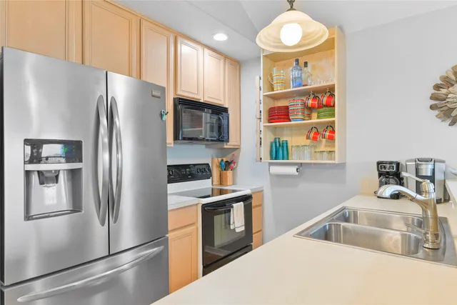 a kitchen with stainless steel appliances granite countertop a refrigerator and a sink