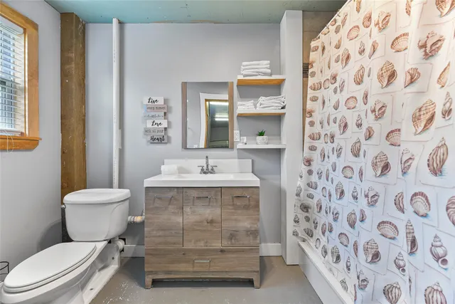 a bathroom with a granite countertop toilet and a sink