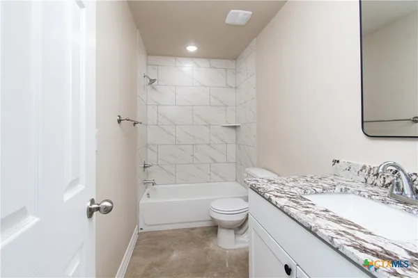 a bathroom with a granite countertop sink a toilet and shower
