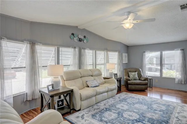 a living room with furniture ceiling fan and a window