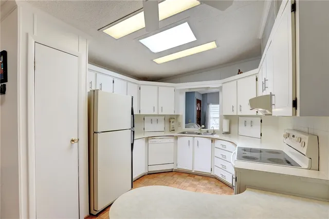a kitchen with granite countertop white cabinets and a sink
