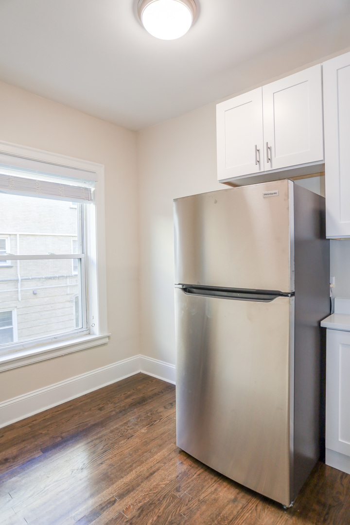 5742 South Stony Is Avenue, Unit 14 Chicago, IL 60637 - Photo 5 of 13 a white refrigerator freezer sitting in a kitchen