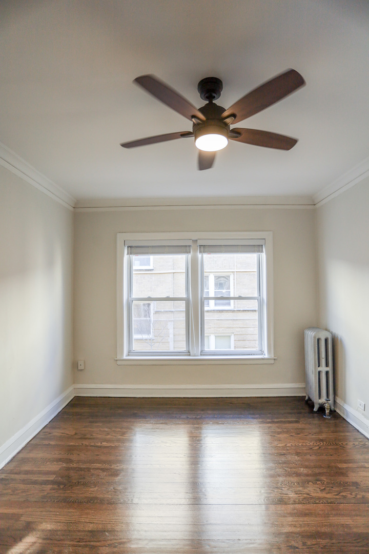 5742 South Stony Is Avenue, Unit 14 Chicago, IL 60637 - Photo 6 of 13 a view of an empty room with wooden floor and a window