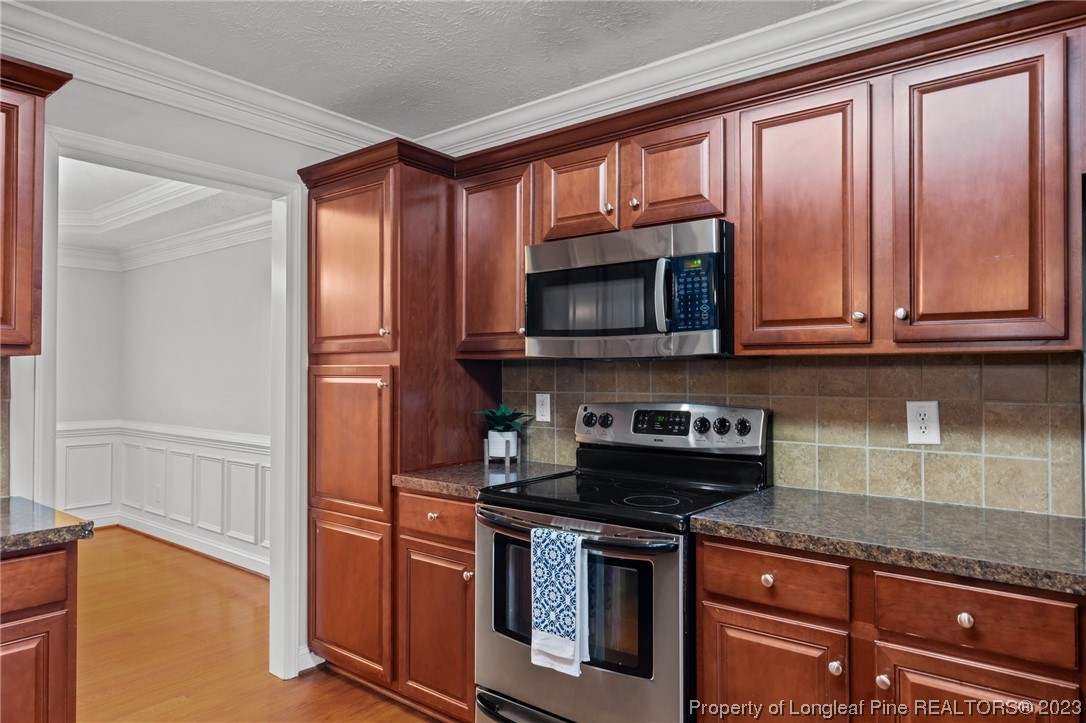 195 Culpepper Road Cameron, NC 28326 - Photo 13 of 46 a kitchen with stainless steel appliances granite countertop a stove microwave and cabinets
