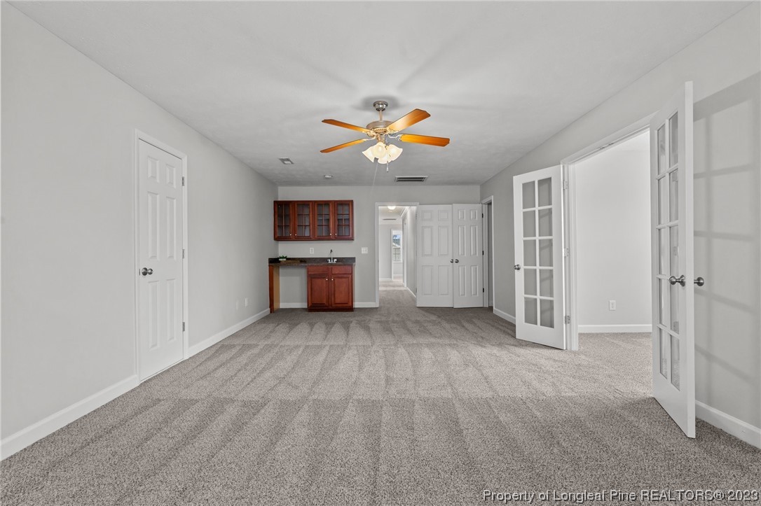 195 Culpepper Road Cameron, NC 28326 - Photo 26 of 46 an empty room with a fireplace and a chandelier fan