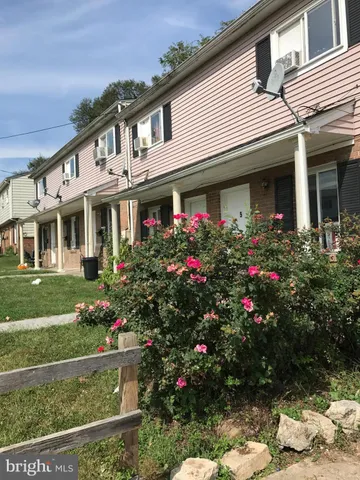 a front view of a house with a yard and a garden