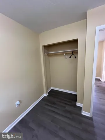 an empty room with wooden floor and closet