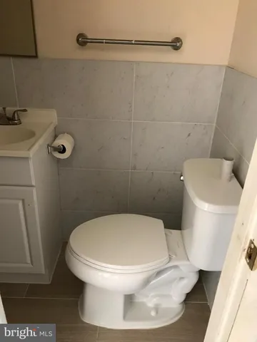 a white toilet sitting next to a white sink and vanity