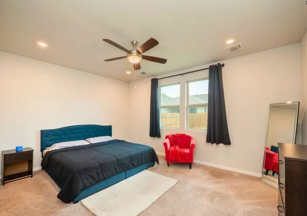 a bedroom with a bed mirror and a large window