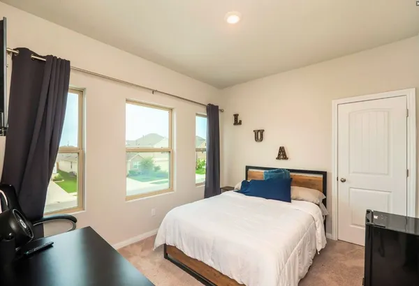 a bedroom with a bed and a large window