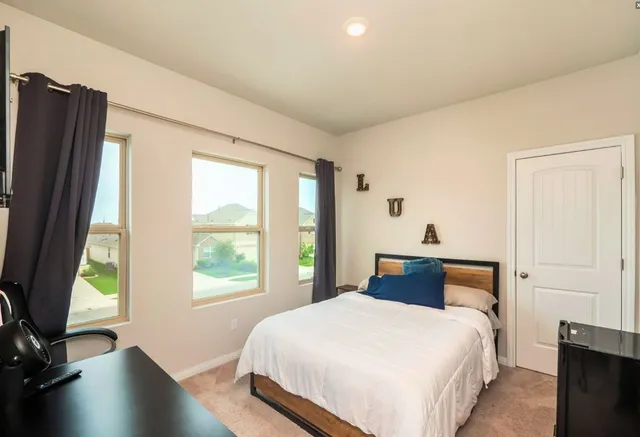 a bedroom with a bed and a large window