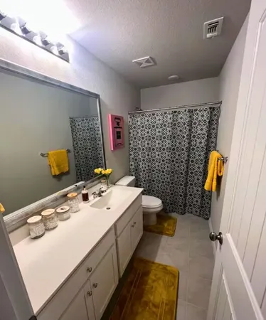a bathroom with a sink mirror vanity and toilet