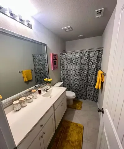 a bathroom with a sink mirror vanity and toilet