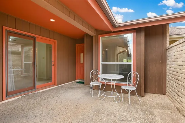 a balcony with table and chairs and a barbeque