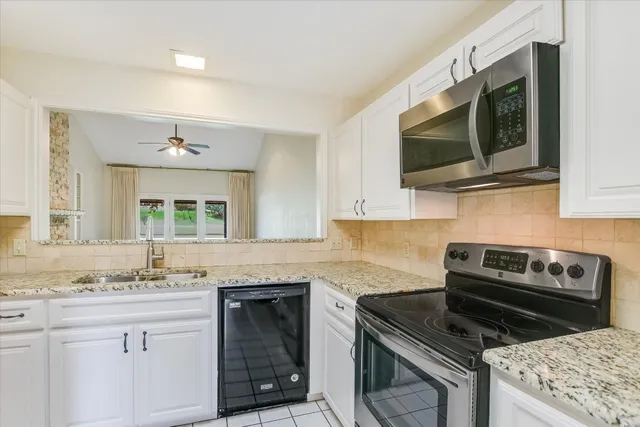 a kitchen with stainless steel appliances granite countertop a stove microwave and sink