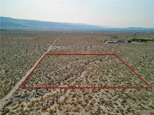 a view of a field with an ocean in the background