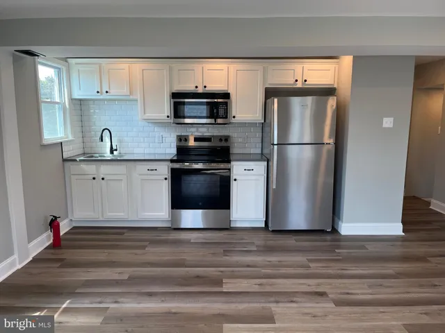 a kitchen with stainless steel appliances granite countertop a refrigerator microwave and sink