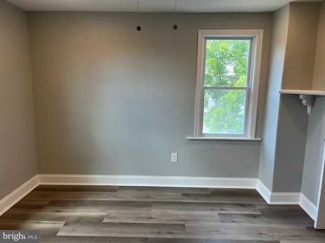 a view of a small space with wooden floor and a window