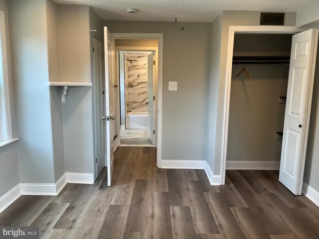 an empty room with wooden floor and closet