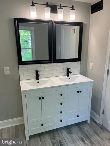 a bathroom with a double vanity sink and mirror