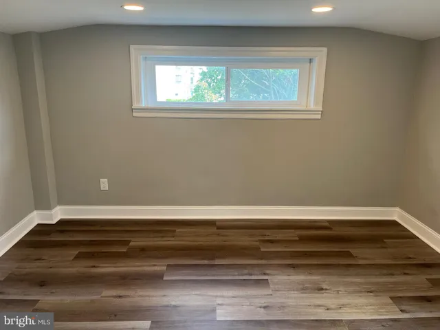 a view of a room with wooden floor and a window