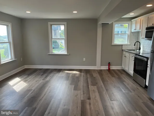an empty room with wooden floor and a window