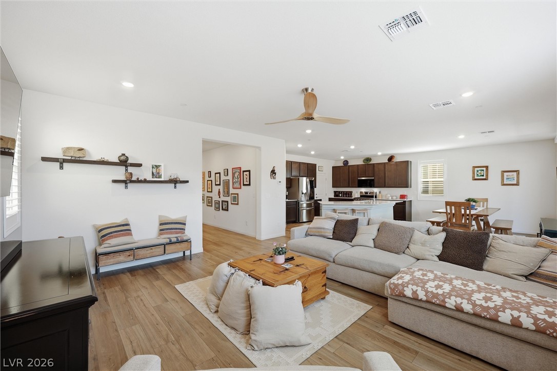 3705 Alla Rocca Avenue Henderson, NV 89044 - Photo 10 of 50 An inviting open-concept living space features warm wood flooring and a modern ceiling fan.