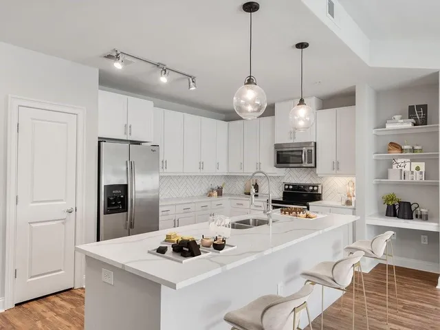 a kitchen with stainless steel appliances kitchen island granite countertop a sink and cabinets