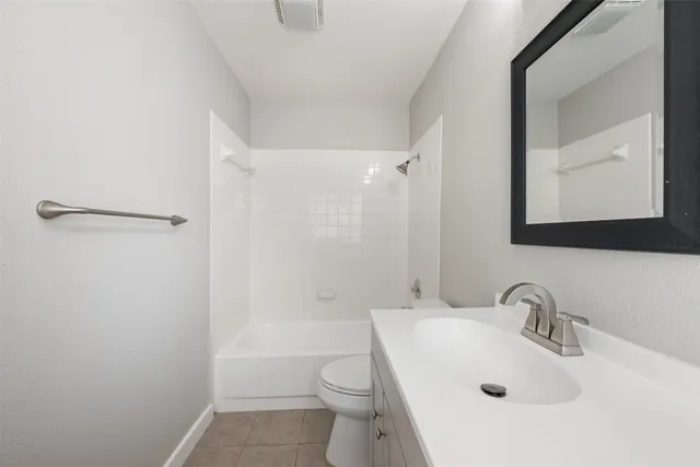an empty room with wooden floor chandelier fan and windows