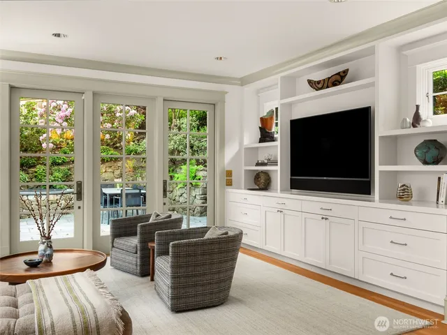 a living room with furniture a flat screen tv and a floor to ceiling window