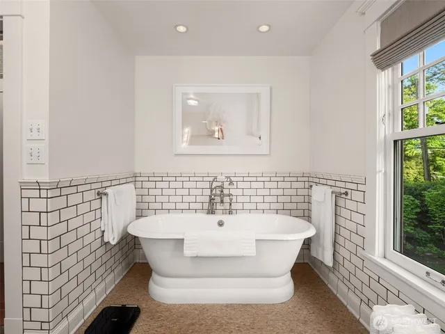 a bathroom with a bathtub and a window