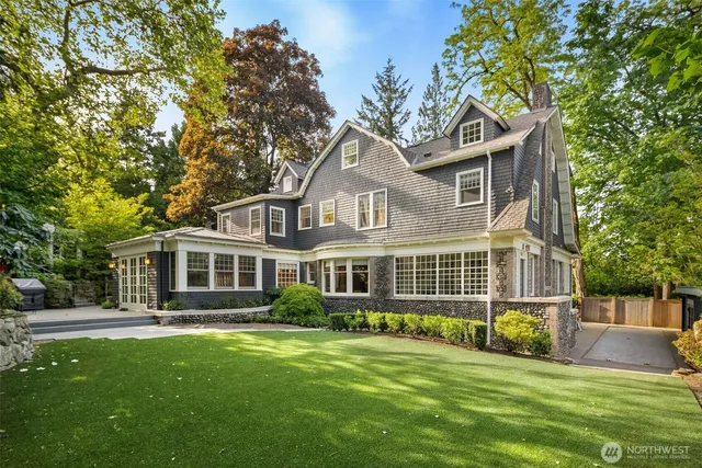 a front view of a house with a garden and trees