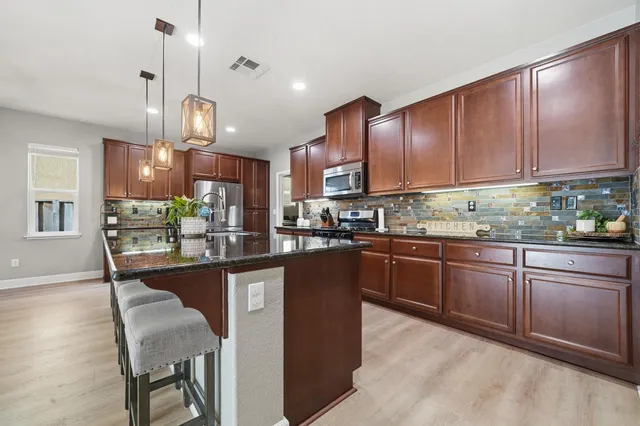 a view of a dining room with furniture a chandelier and wooden floor