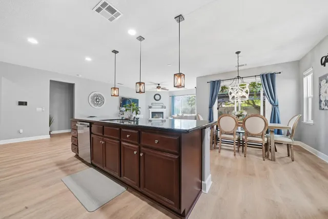 a dining room with furniture a chandelier and wooden floor