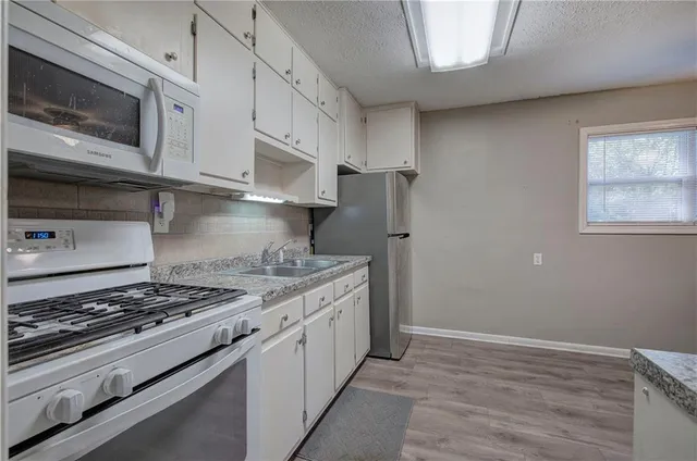 a kitchen with stainless steel appliances granite countertop a stove and a microwave
