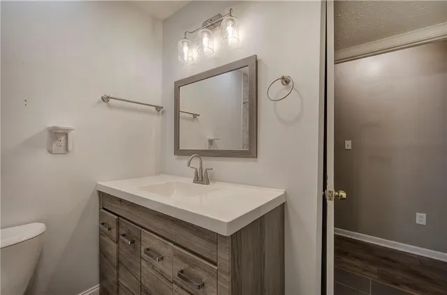 a bathroom with a sink toilet and mirror