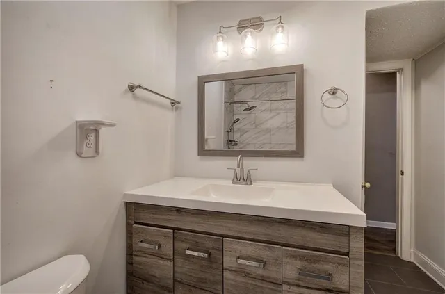 a bathroom with a sink a toilet and mirror