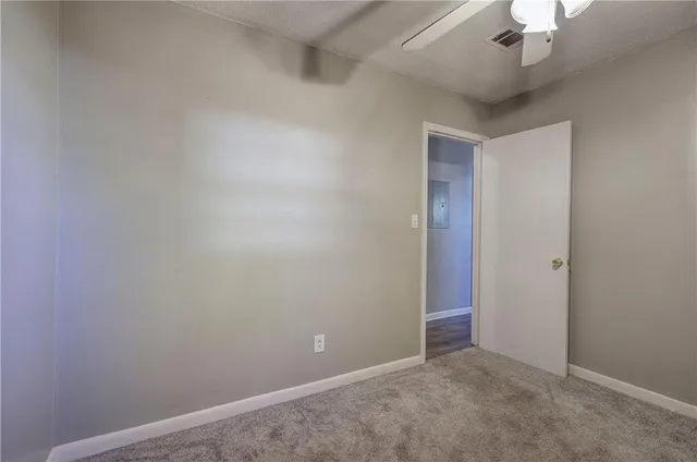 an empty room with a ceiling fan and closet