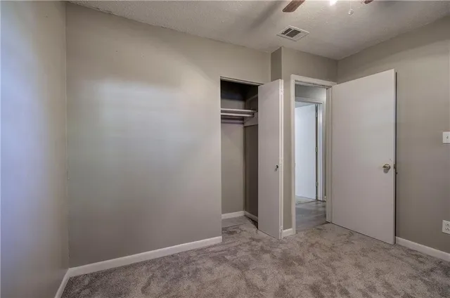 an empty room with closet and windows