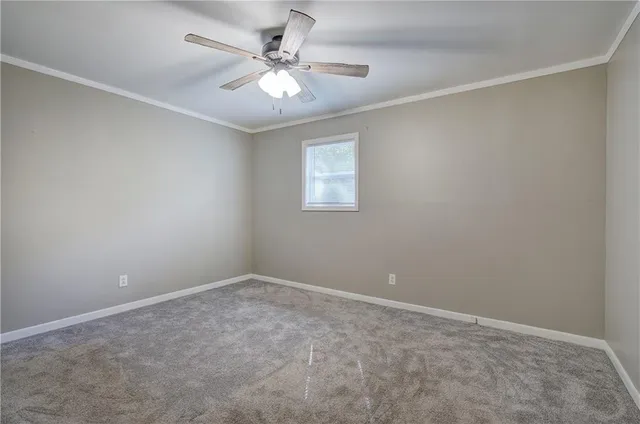 an empty room with a chandelier fan
