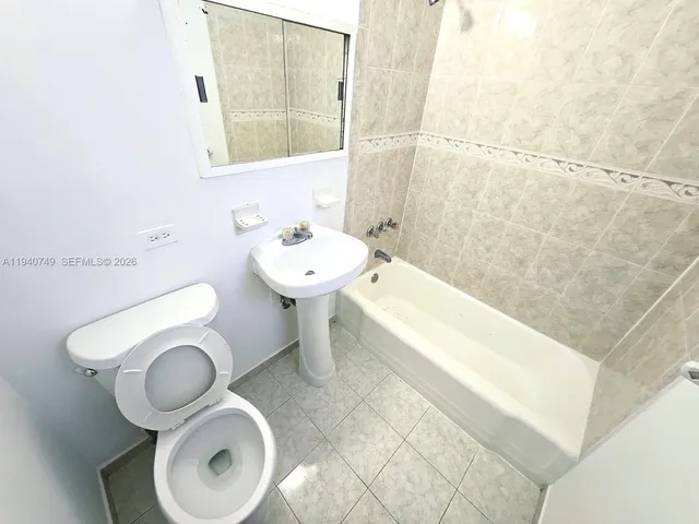 a bathroom with a sink mirror bathtub and toilet