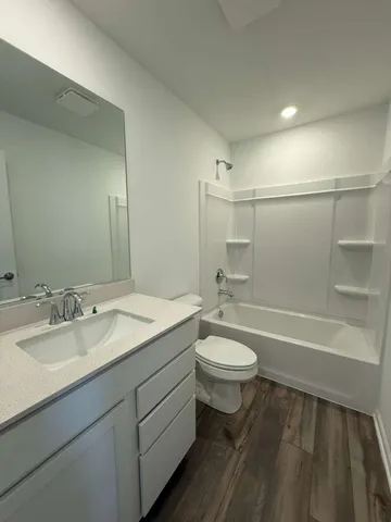 a bathroom with a double vanity sink toilet mirror and bathtub