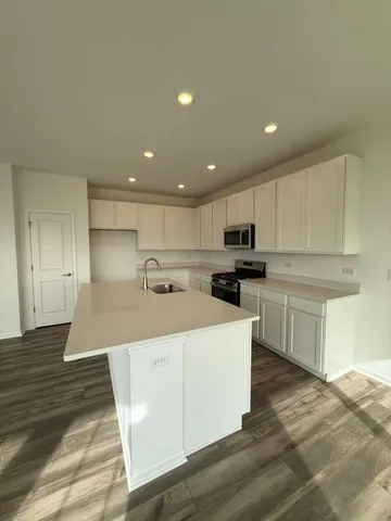 a kitchen with kitchen island white cabinets and stainless steel appliances