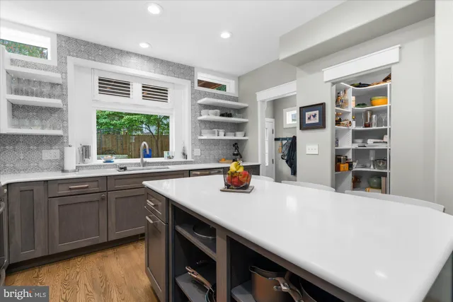 a kitchen with a stove a refrigerator and a sink with wooden floor